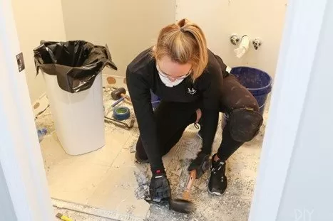 Removing the old tiles of the bathroom.